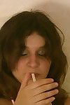 Drunk teen brunette isida drinking vodka with juice with the addition of smoking