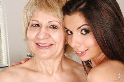 Lusty granny with tiny tits poses naked with her teen lesbo babe