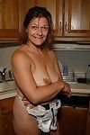 Granny Ivee showing off tattoos and shaved mature vagina in kitchen