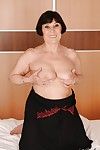Smiley brunette granny uncovering her fatty curves on the bed