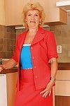 Lecherous blonde granny with round jugs stripping in the kitchen