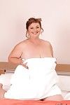 Big busted mature plumper posing barely clothed on the bed